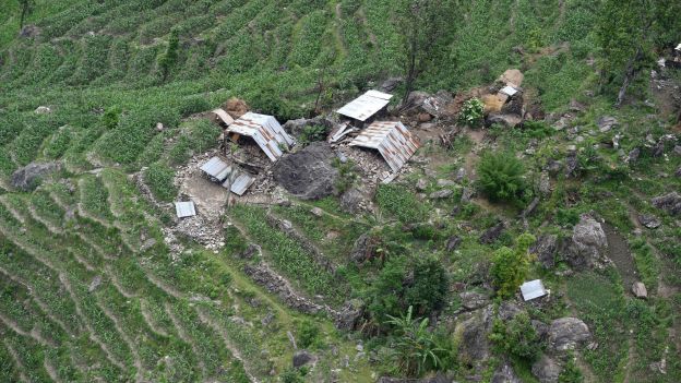 This aerial view from an Indian Army helicopter shows a cluster of damaged homes in the hills of Gorkha some 60kms north-west of Kathmandu on April 28, 2015.  Hungry and desperate Nepalese villagers rushed towards a relief helicopter begging to be airlifted to safety after a huge earthquake that has killed at least 4,349 people devastated their remote community.    AFP PHOTO / SAJJAD HUSSAIN