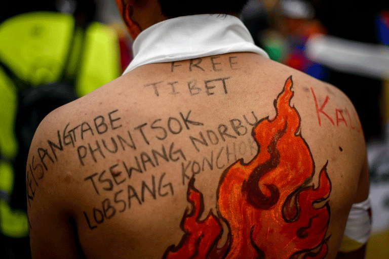 Un activiste tibétain manifeste devant les bureaux des Nations Unies à Genève. Sur son dos, les noms de compatriotes morts après s'être immolés en signe de protestation contre la domination chinoise dans les régions à population tibétaine. 22 octobre 2013 