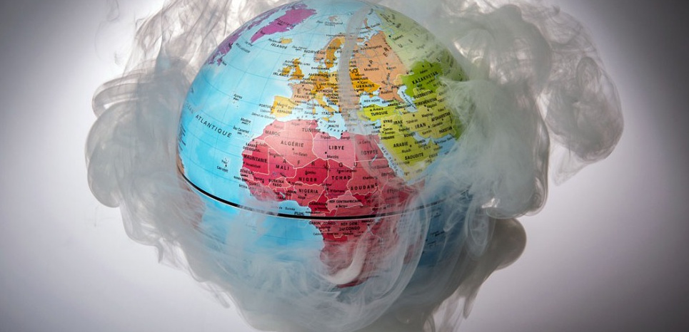 A picture taken on November 10, 2015 shows a small globe surrounded by smoke to illustrate global warming. France will be hosting and presiding the 21st Session of the Conference of the Parties to the United Nations Framework Convention on Climate Change (COP21/CMP11), also known as Paris 2015 from November 30 to December 11. AFP PHOTO / LIONEL BONAVENTURE / AFP / LIONEL BONAVENTURE