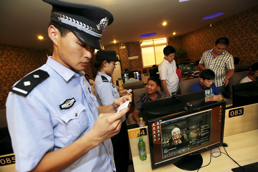 --FILE--Chinese police and law enforcement officers check ID cards of young netizens playing online games or watching online videos at an Internet cafe in Zaozhuang city, east Chinas Shandong province, 31 July 2013. Chinese Internet users are now required to register their real names to upload videos to Chinese online video sites, an official body said, as the Communist Party tightens its control of the Internet and media to suppress anti-government sentiment. The new rule has been implemented to prevent vulgar content, base art forms, exaggerated violence and sexual content in Internet video having a negative effect on society, Chinas State Administration of Press, Publication, Radio, Film and Television (SARFT) said on its website. The rule is aimed at online dramas, micro-films and other online audio-visual programmes, the statement on the website said. It gave no further explanation.