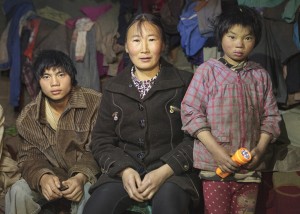 Huanming LI (au milieu) avec son voisin et sa jeune soeur, Province de Guizhou, district de Nayong, ville de Bijie, Chine.  9 décembre 2015 
