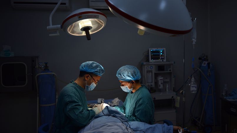 TO GO WITH China-health-employment-social-lifestyle,FEATURE by Tom HANCOCK This photo taken on August 9, 2013 shows plastic surgeon Wang Xuming (L) performing a "special" nose operation on a patient at his clinic in the southwest Chinese city of Chongqing. China stands behind only the US and Brazil for the number of plastic surgery operations performed each year, according to the International Society of Aesthetic Plastic Surgeons. AFP PHOTO / Peter PARKS / AFP PHOTO / PETER PARKS