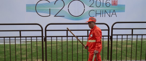 A cleaning worker walks around a hotel and signage for the G20 summit in Hangzhou on September 2, 2016. Factories have been closed to ensure blue skies, potential troublemakers detained and a quarter of the residents have left: welcome to Hangzhou, a city China's ruling Communist Party is determined will look its best for the G20 summit. / AFP PHOTO / NICOLAS ASFOURI / TO GO WITH AFP STORY: China-G20-diplomacy , Focus by Tom HANCOCK