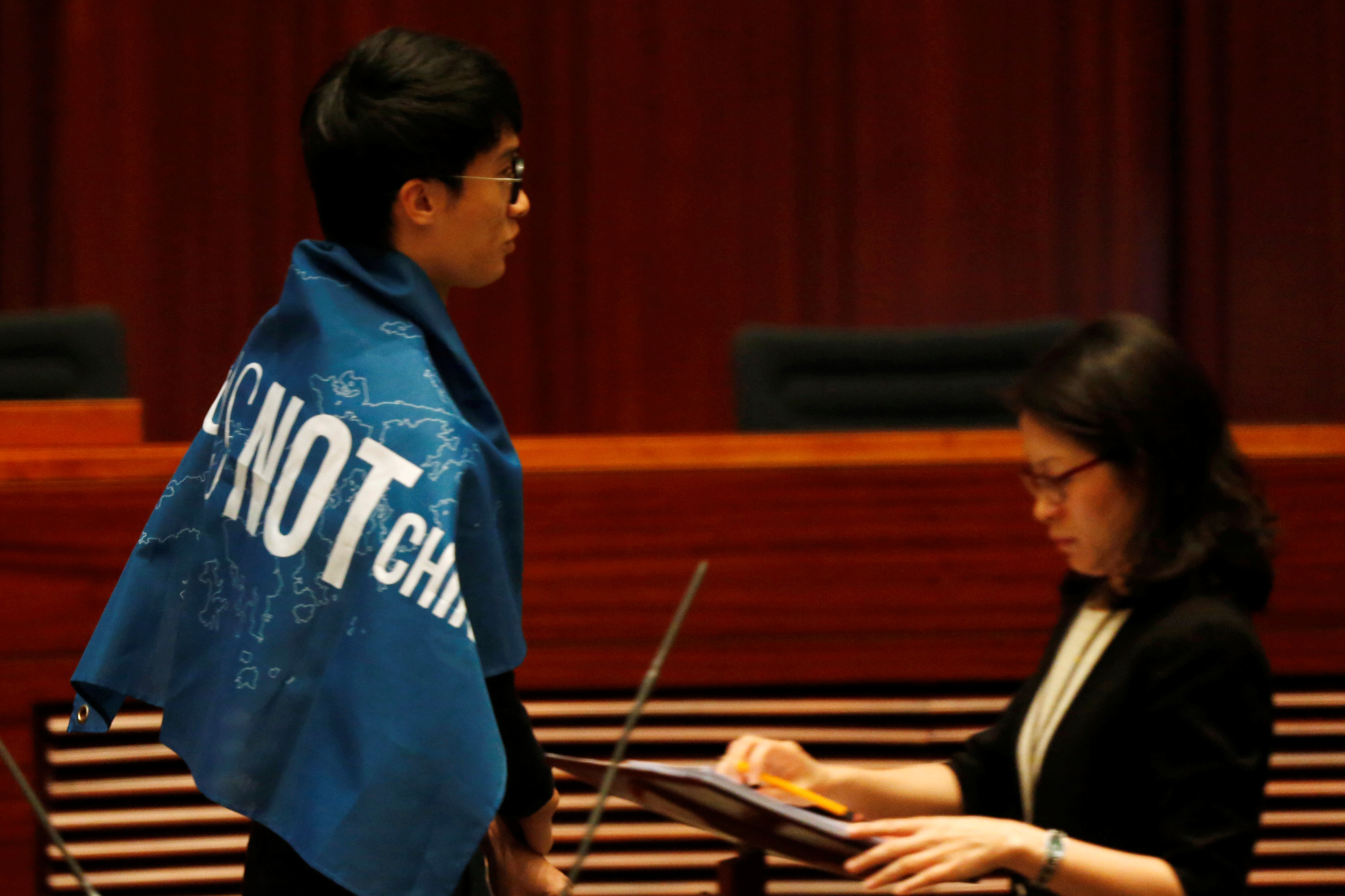 Newly-elected lawmaker Baggio Leung wears a banner "Hong Kong is not China" while taking oath at the Legislative Council in Hong Kong, China October 12, 2016. REUTERS/Bobby Yip - RTSRV8Z